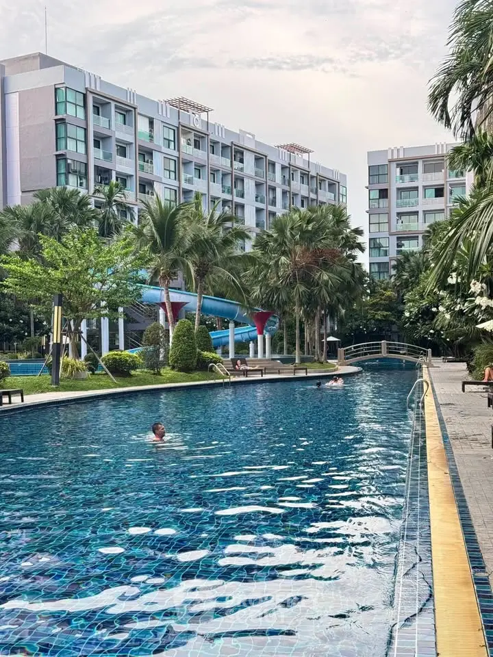 Luxurious residential complex with a stunning outdoor pool and lush greenery, perfect for relaxation and leisure.