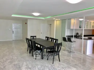 Spacious open-plan dining area with modern kitchen and elegant marble flooring.