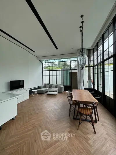 Spacious modern living room with large windows and stylish dining area