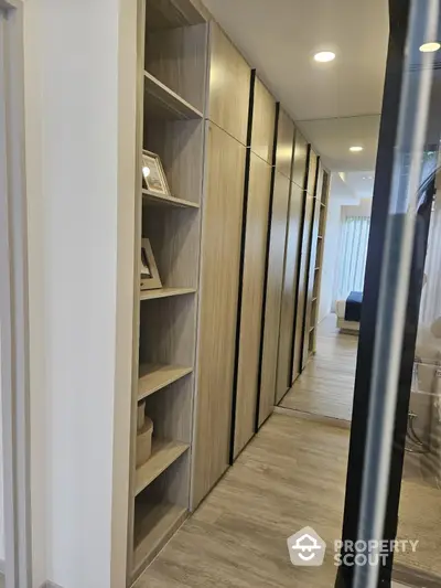 Modern hallway with built-in wooden shelves and sleek design