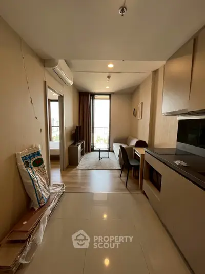 Modern apartment interior with open layout, featuring a cozy living area and sleek kitchen design.