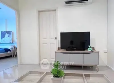 Modern living room with sleek TV stand and air conditioning, adjacent to a cozy bedroom.
