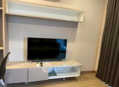 Modern living room with sleek TV stand and mounted shelf, perfect for cozy entertainment setup.