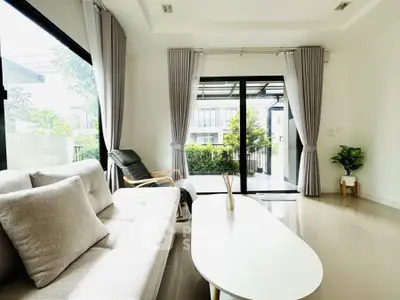 Bright modern living room with large windows and garden view.