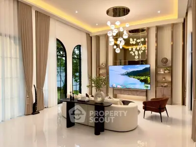 Luxurious living room with high ceilings, elegant chandelier, and large windows offering a serene garden view.