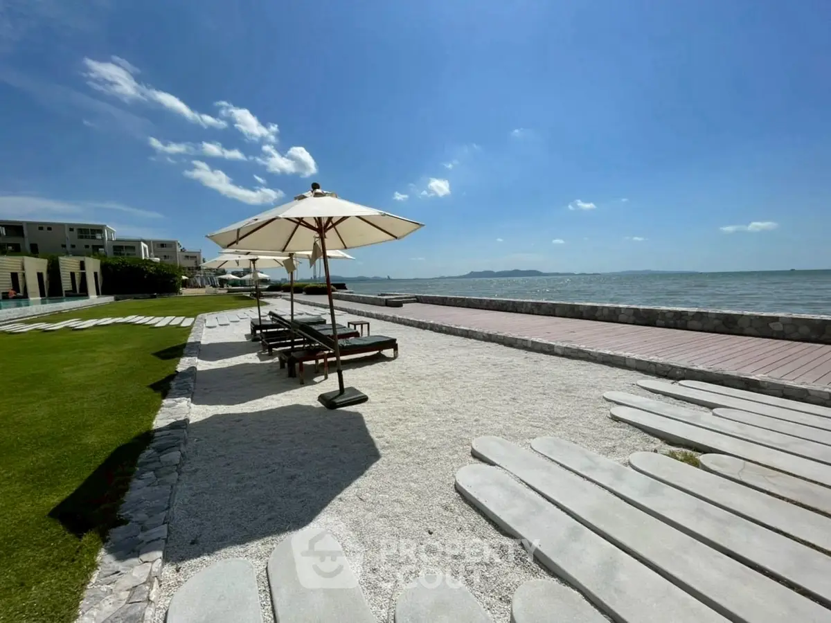Stunning beachfront property with expansive ocean views and elegant outdoor seating area.