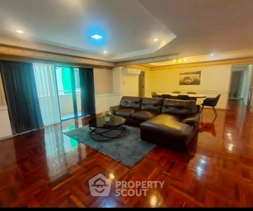 Spacious living room with elegant wooden flooring and modern furniture in a luxurious apartment.