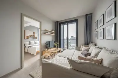 Modern living room with large windows and cozy seating, adjacent to a stylish bedroom with city view.