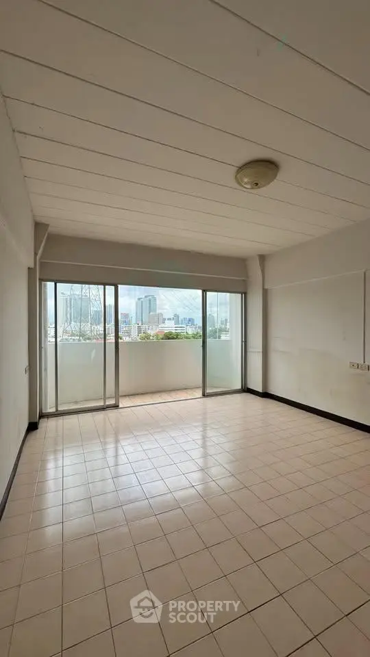Spacious empty room with large windows and city view, perfect for customization.