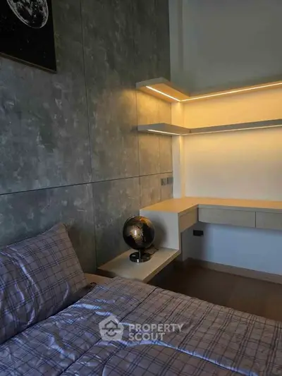 Modern bedroom with stylish lighting and globe decor on side table.