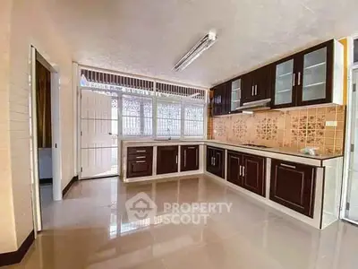 Spacious kitchen with modern cabinetry and ample natural light, perfect for culinary enthusiasts.