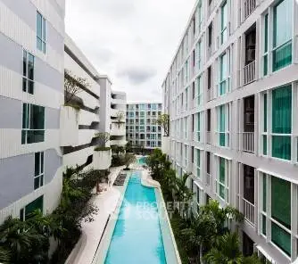 Luxurious modern apartment complex with stunning pool view and lush greenery.