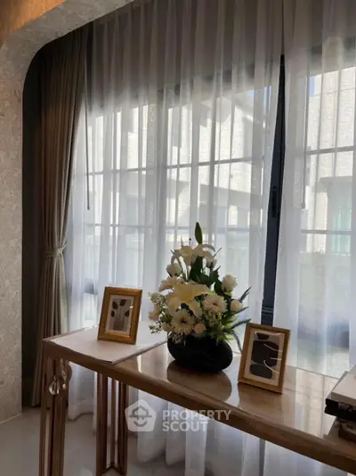 Elegant interior with floral arrangement and framed art by large window