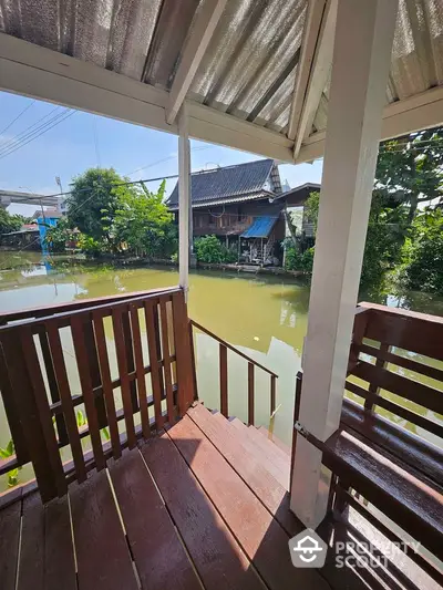 Charming riverside view from a wooden porch, perfect for serene living.