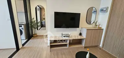 Modern living room with sleek TV setup and stylish decor in a contemporary apartment.