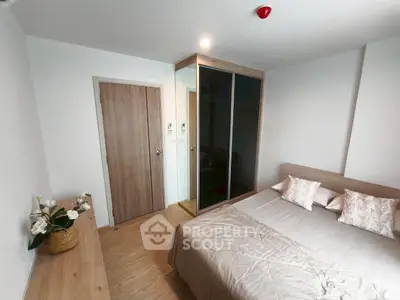 Modern bedroom with wooden flooring, sleek wardrobe, and cozy bed setup.