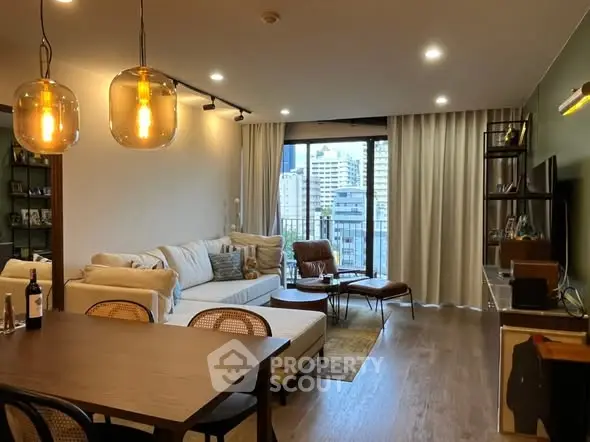 Modern living room with stylish decor and city view from balcony, featuring cozy seating and elegant lighting.