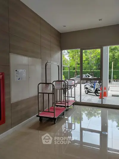 Modern building entrance with luggage carts and large windows offering a view of the street.