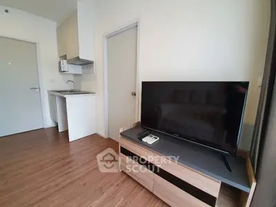 Modern studio apartment with sleek TV unit and compact kitchen area, perfect for urban living.