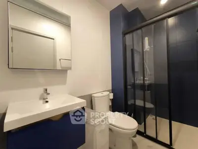 Modern bathroom with sleek shower and stylish vanity in contemporary apartment.