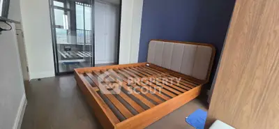 Spacious bedroom with modern wooden bed frame and large window view