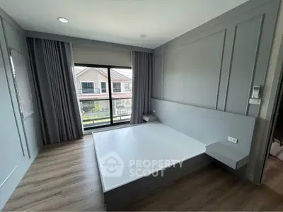 Spacious modern bedroom with large window and elegant paneling