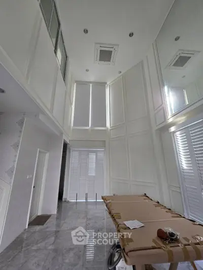 Spacious high-ceiling room with marble flooring and modern design