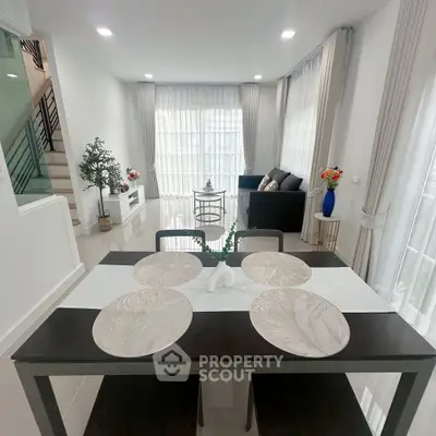Modern living room with elegant dining area and stylish decor in a bright, open space.
