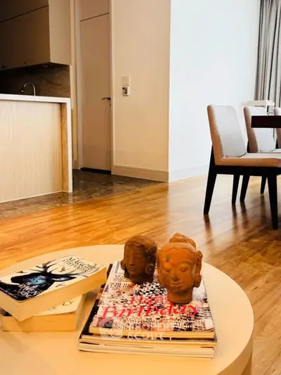 Modern living room with stylish decor and open kitchen layout, featuring wooden flooring and elegant dining area.