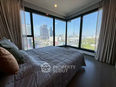 Luxurious bedroom with panoramic city view and floor-to-ceiling windows.