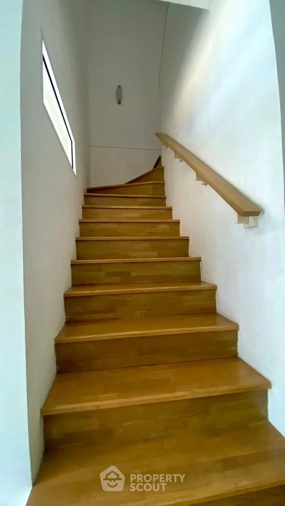 Elegant wooden staircase with sleek handrail in modern home interior