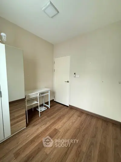 Minimalist bedroom with wooden flooring and white furniture