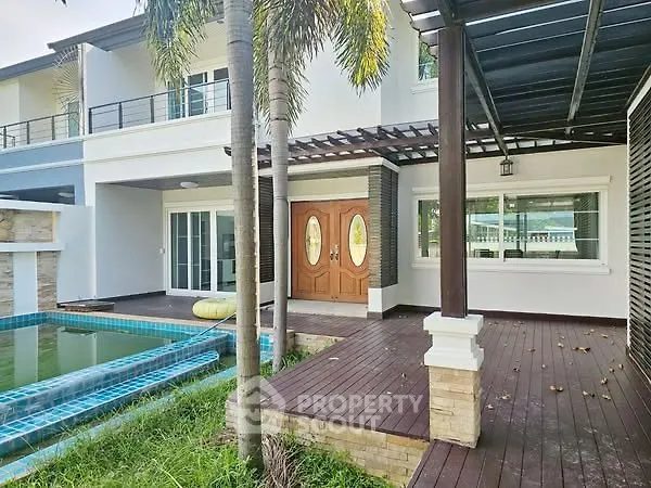 Stunning modern home with pool and spacious wooden deck, perfect for luxurious outdoor living.