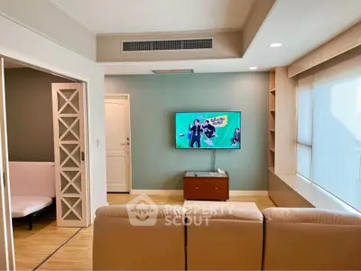 Spacious living room with modern decor and wall-mounted TV, perfect for relaxation and entertainment.