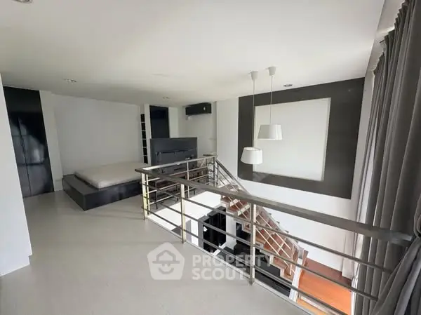 Modern loft-style bedroom with sleek design and open staircase