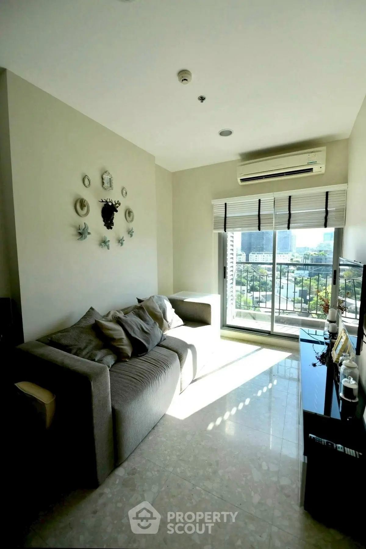 Bright living room with modern decor and city view from large window.