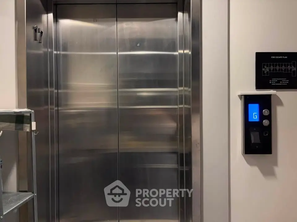 Modern elevator with sleek metallic doors in a contemporary building lobby.