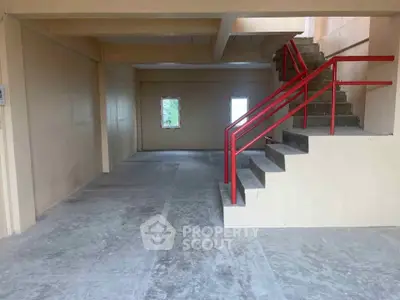 Spacious building interior with red staircase and natural light