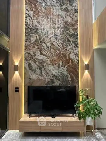 Luxurious living room with stunning marble accent wall and modern TV setup