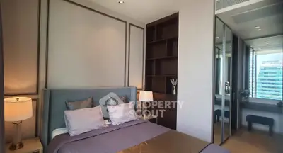 Luxurious bedroom with modern decor and city view, featuring elegant lighting and mirrored wardrobe.
