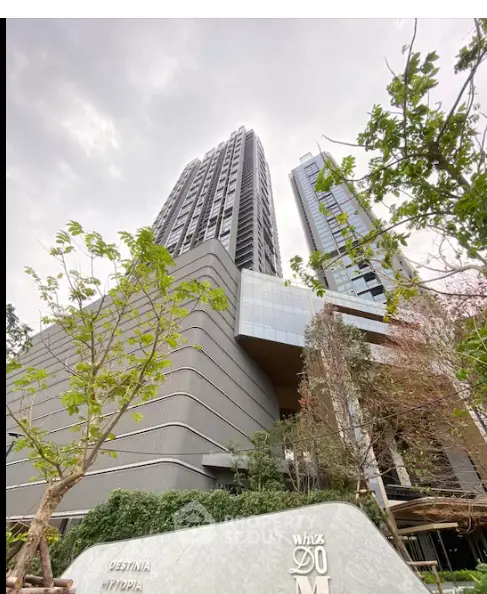 Modern high-rise building with lush greenery and contemporary architecture.