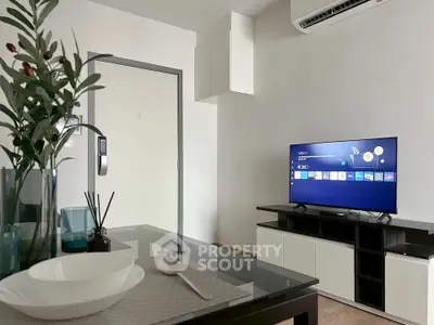 Modern living room with sleek furniture and wall-mounted TV, perfect for relaxation and entertainment.