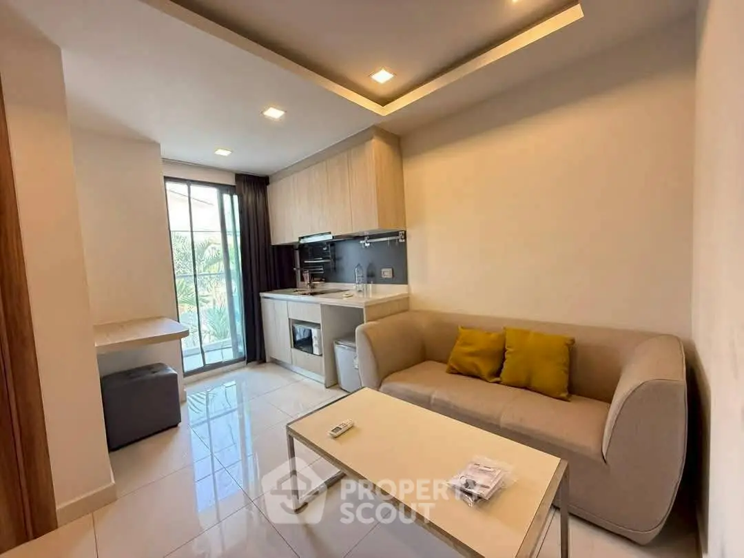 Modern living room with open kitchen, featuring sleek design and natural light.