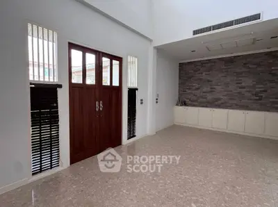 Spacious modern living room with high ceiling and elegant stone accent wall