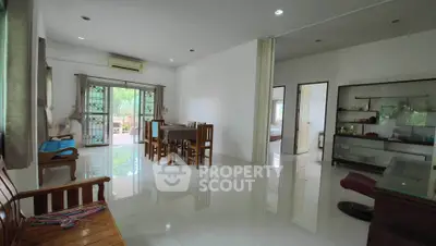Spacious living room with dining area and large windows in modern home