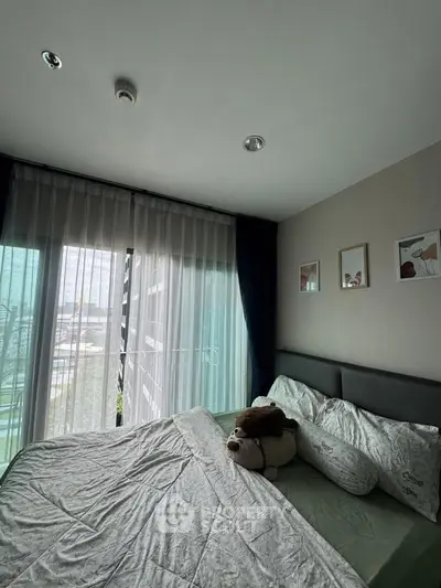 Cozy bedroom with large window and modern decor in a stylish apartment.