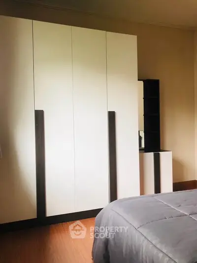 Spacious bedroom with modern wardrobe and cozy bedding
