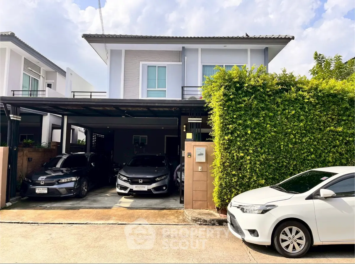 Modern two-story house with carport and lush greenery