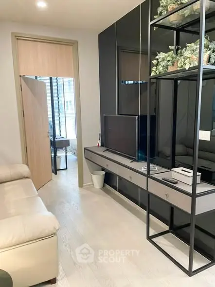 Modern living room with sleek furniture and stylish decor, featuring a cozy sofa and a flat-screen TV.