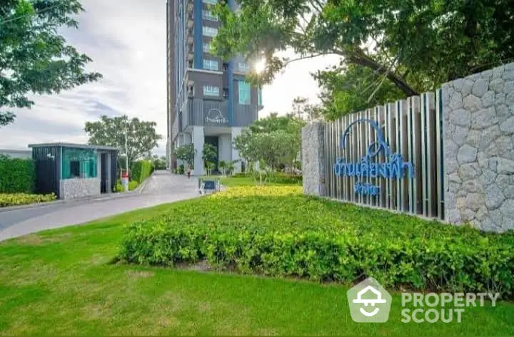 Modern condominium entrance with lush greenery and stylish architecture